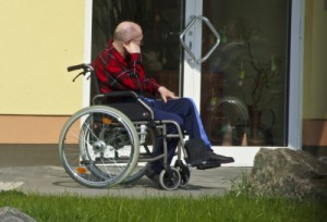 Mann im Rollstuhl als Zeichen einer behindertengerechten Immobilie